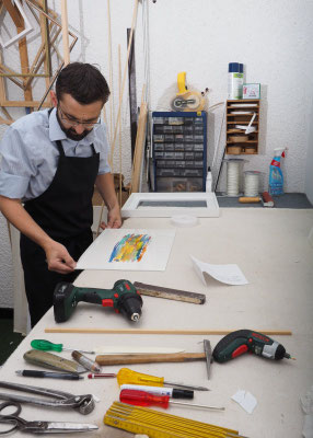 Individuelle Einrahmung eines Kunstwerks am Arbeitstisch in unserer Darmstädter Rahmenwerkstatt.