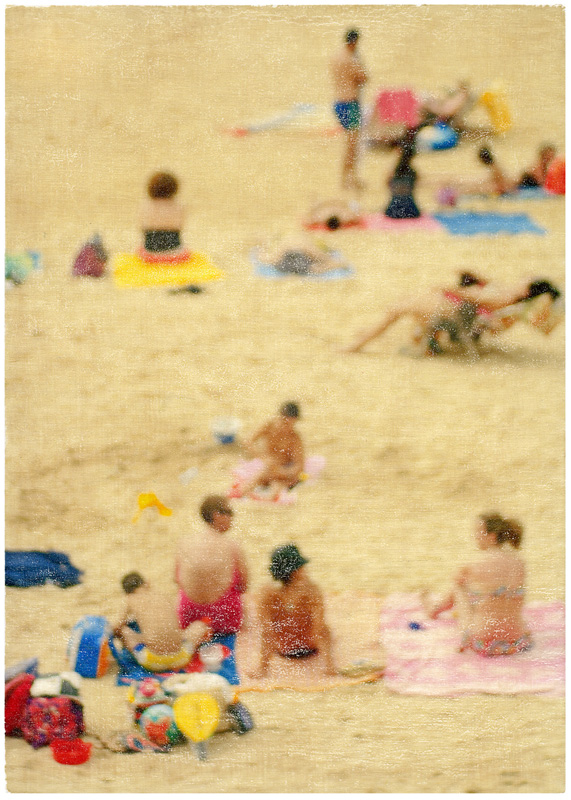 Foto-Mischtechnik von SPOXO -Buntes treiben lassen- Ein belebter Sandstrand aus der Vogelperspektive zeigt dutzende Badegäste verteilt im Sand, bunte Handtücher, Spielzeug, Sonnenschirme, Kinder und Erwachsene in allen Posen des Nichtstuns. 